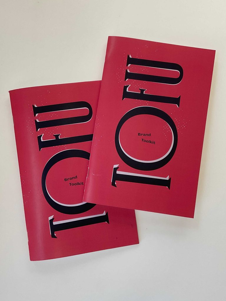 Two pink printed brand toolkit zines with a large Tofu Type Foundry logo covering the font.