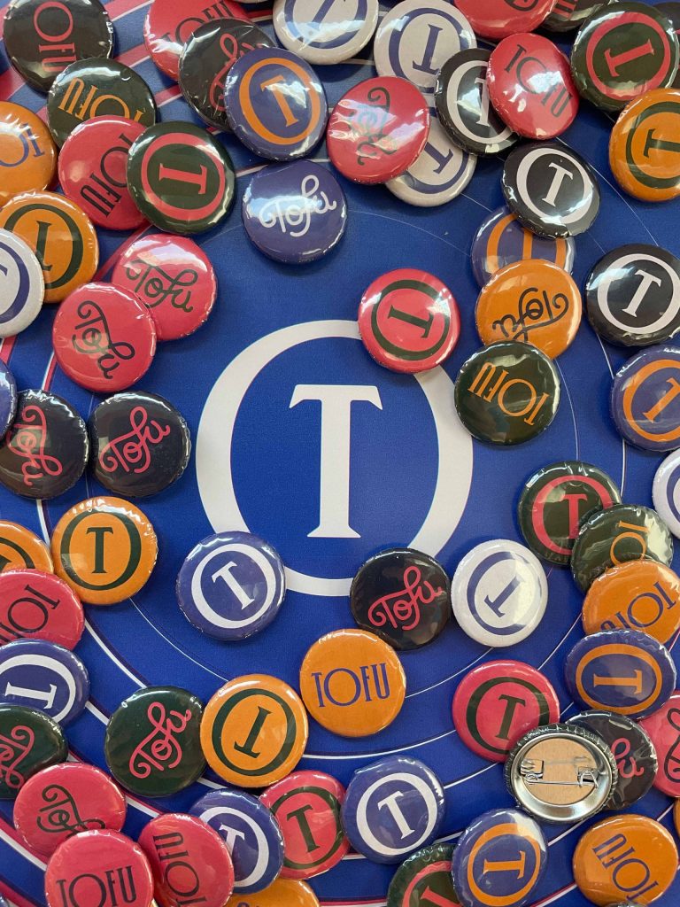 Dozens of colourful branded buttons covering up a Tofu Type Foundry icon.